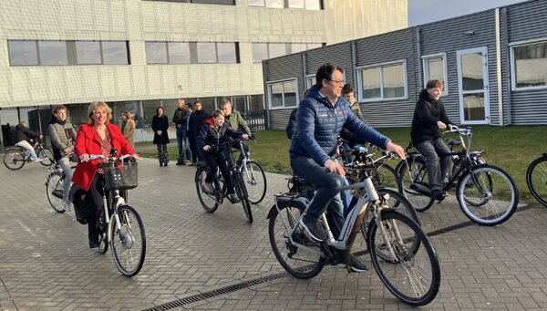 Wethouder Antoinette Maas en docent Marc Wiskerke maken met de eerste groep leerlingen de meters op de fiets